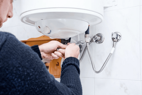 Plombier qui vidange un chauffe eau