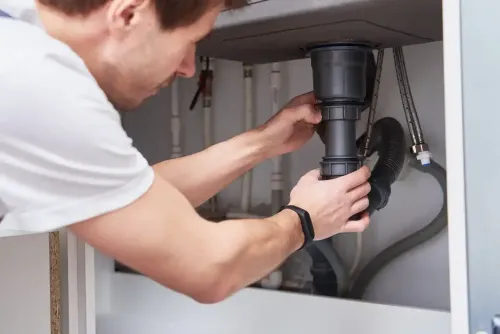nettoyage evier par un plombier en t-shirt blanc